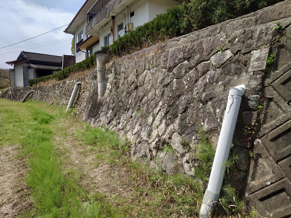 補修前の石積み擁壁。目地が傷み、草が生え、内部に空洞ができている