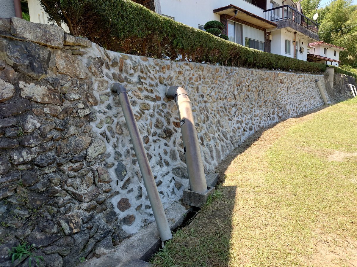 モルダム工法で補修を終えた石積み擁壁。目地が充填され、石積みの表情はそのまま残っている